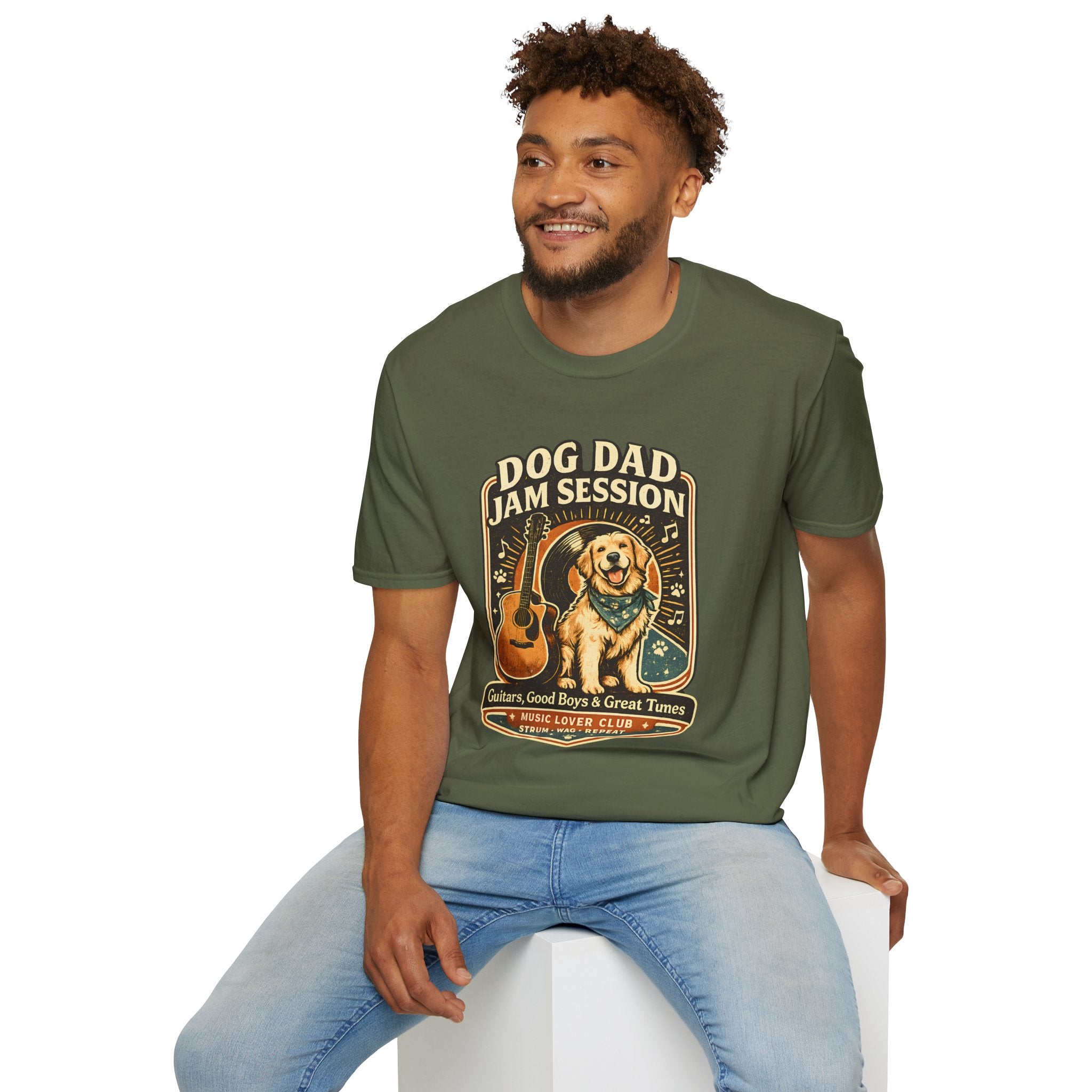 Man wearing a dark gray t-shirt with cartoon character prints, sitting on a white stool against a white background.