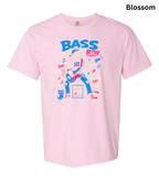 A light pink short-sleeve t-shirt with a colorful graphic on the front featuring a dancing bass player, musical notes, and the text 'BASS BETTER'. The word 'Blossom' is printed in black in the top right corner.