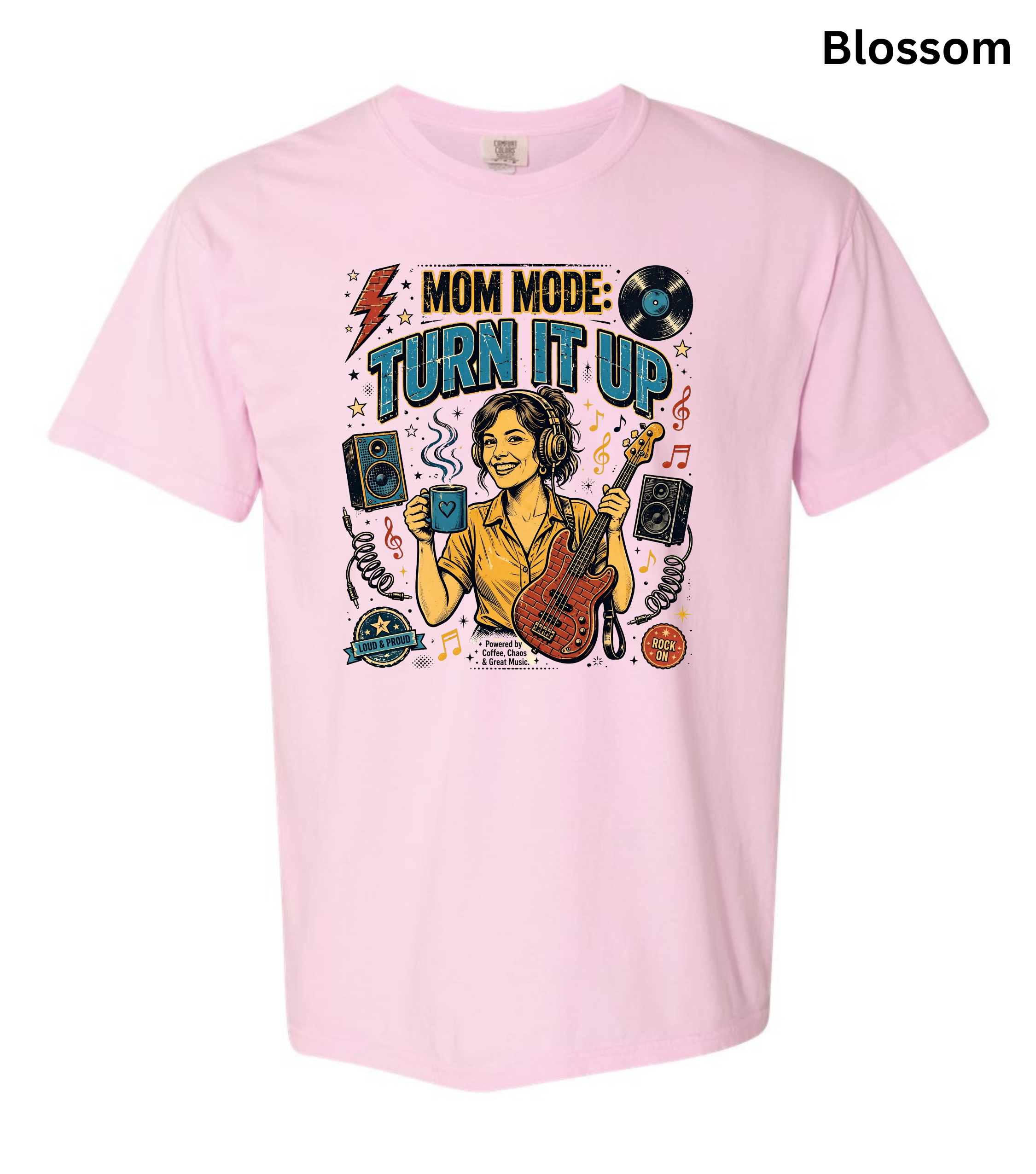 A light pink short-sleeve t-shirt with a colorful graphic on the front featuring a woman playing guitar and the text 'MOM MODE: TURN IT UP'. The word 'Blossom' is printed in black in the top right corner.