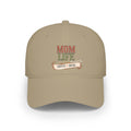 A beige baseball cap featuring a front graphic that reads 'MOM LIFE' with 'COFFEE & MUSIC' on a banner below, shown on a plain white background.