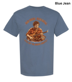 A blue short-sleeve graphic t-shirt on a white background, featuring a vintage-style illustration of a man playing an acoustic guitar with the text 'AND MADE NEWARK! I'LL BE BY THE GATESHIRE COASTAL'. A 'Blue Jean' color label is visible in the top right corner.