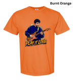 An orange short-sleeve crewneck t-shirt featuring a graphic print of a man playing an electric guitar with the text 'PLAY IT LOUD' underneath. The text 'Burnt Orange' is written in black at the top right corner.