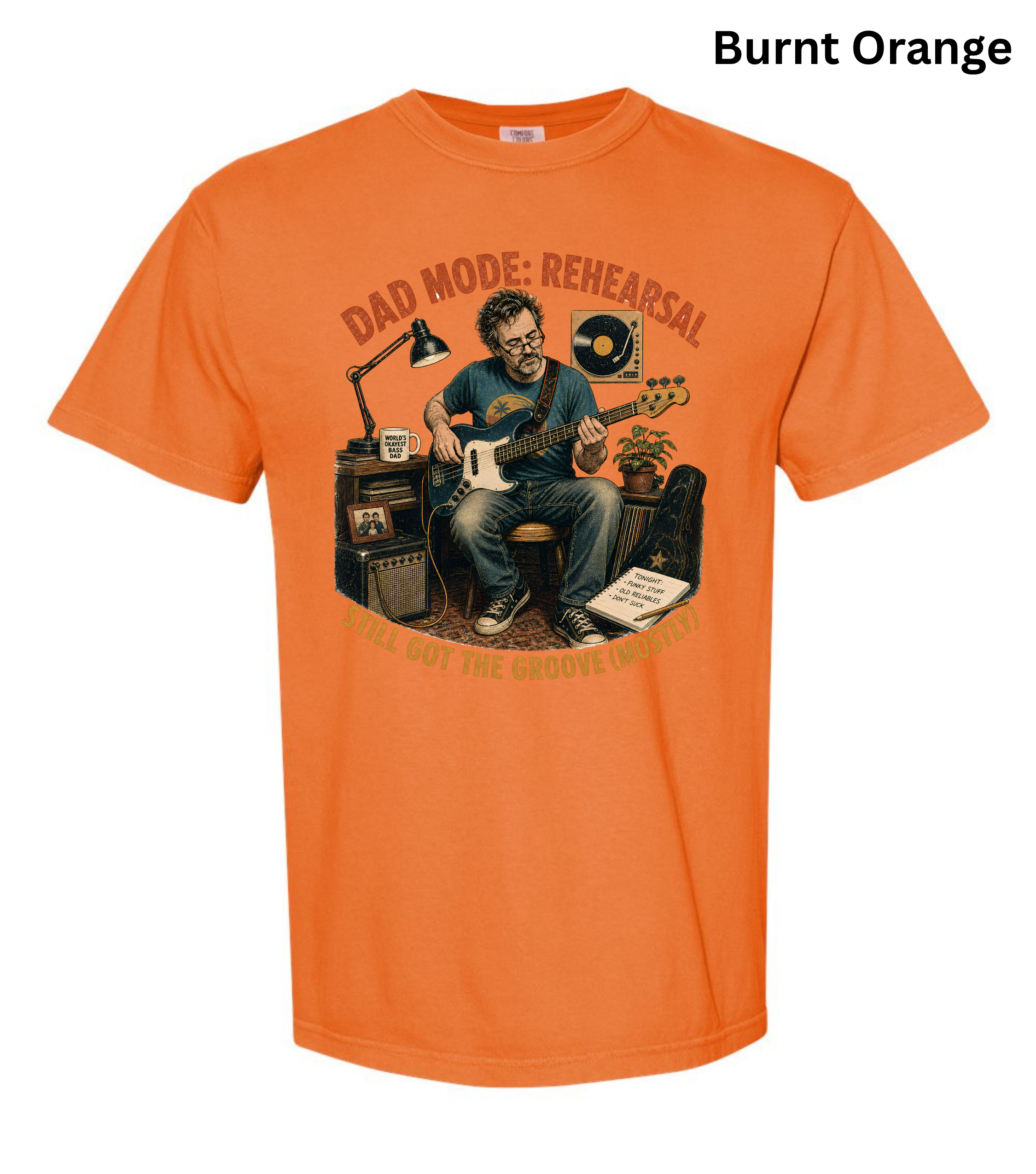 An orange short-sleeve crewneck t-shirt featuring a graphic illustration of a man playing an electric guitar in front of amplifiers, with the text 'DAD MODE: REHEARSAL' arched above and 'DON'T WASH THE GUNNY-WATER OFF YOUR FEET' below. The text 'Burnt Orange' is printed in black in the top right corner.