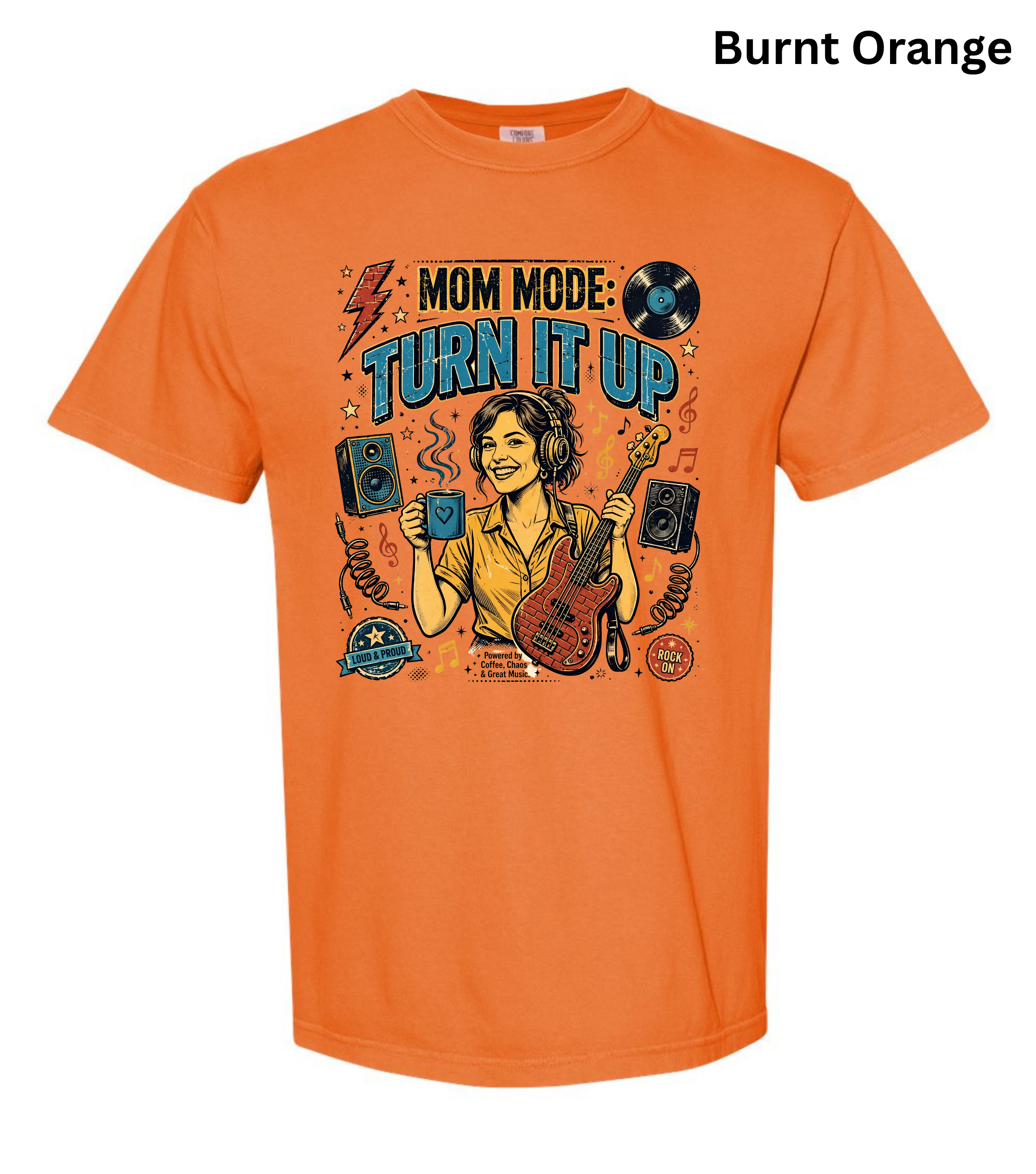 An orange short-sleeve t-shirt with a colorful graphic print on the front featuring a woman playing an electric guitar and the text 'MOM MODE: TURN IT UP'. The text 'Burnt Orange' is written in black at the top right corner.