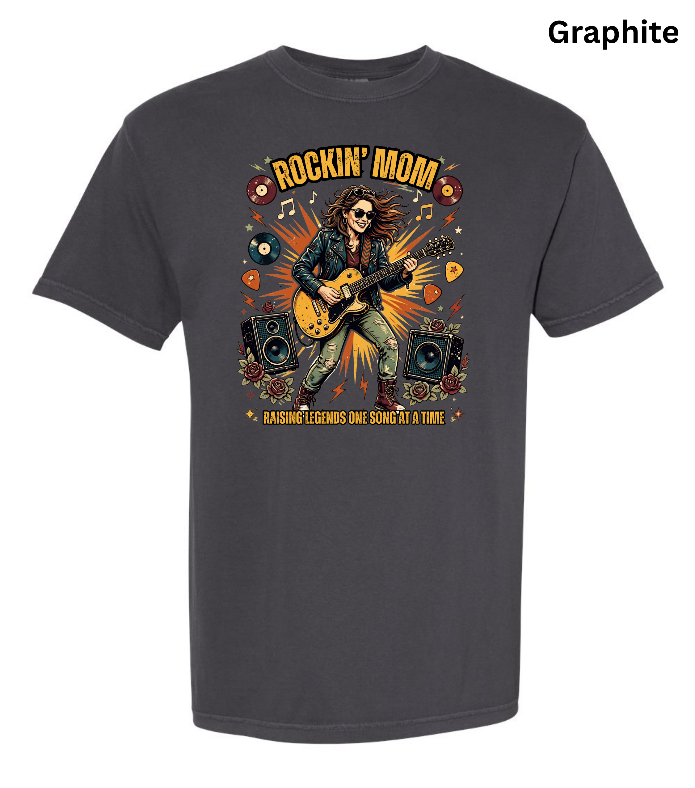 A dark charcoal gray t-shirt with a colorful graphic print of a woman playing an electric guitar surrounded by speakers and musical notes, with the text 'ROCKIN' MOM' and 'BASSING LEGENDS ONE SOMETHING AT A TIME'. The word 'Graphite' is printed in the top right corner.