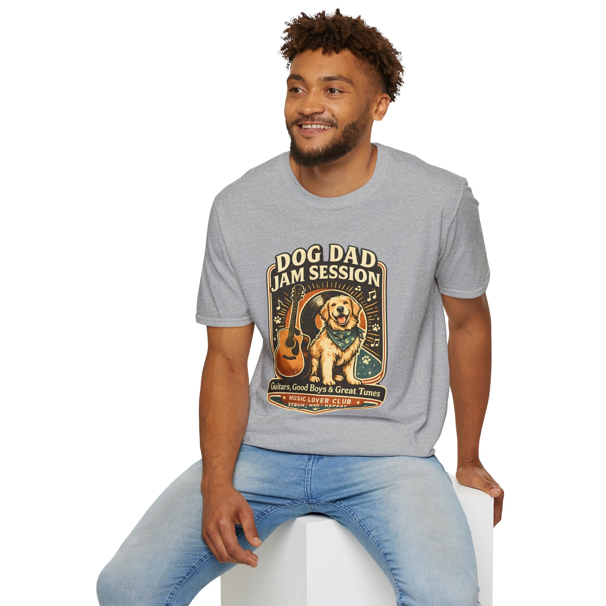 Man wearing a gray t-shirt with a graphic design sitting on a white stool.