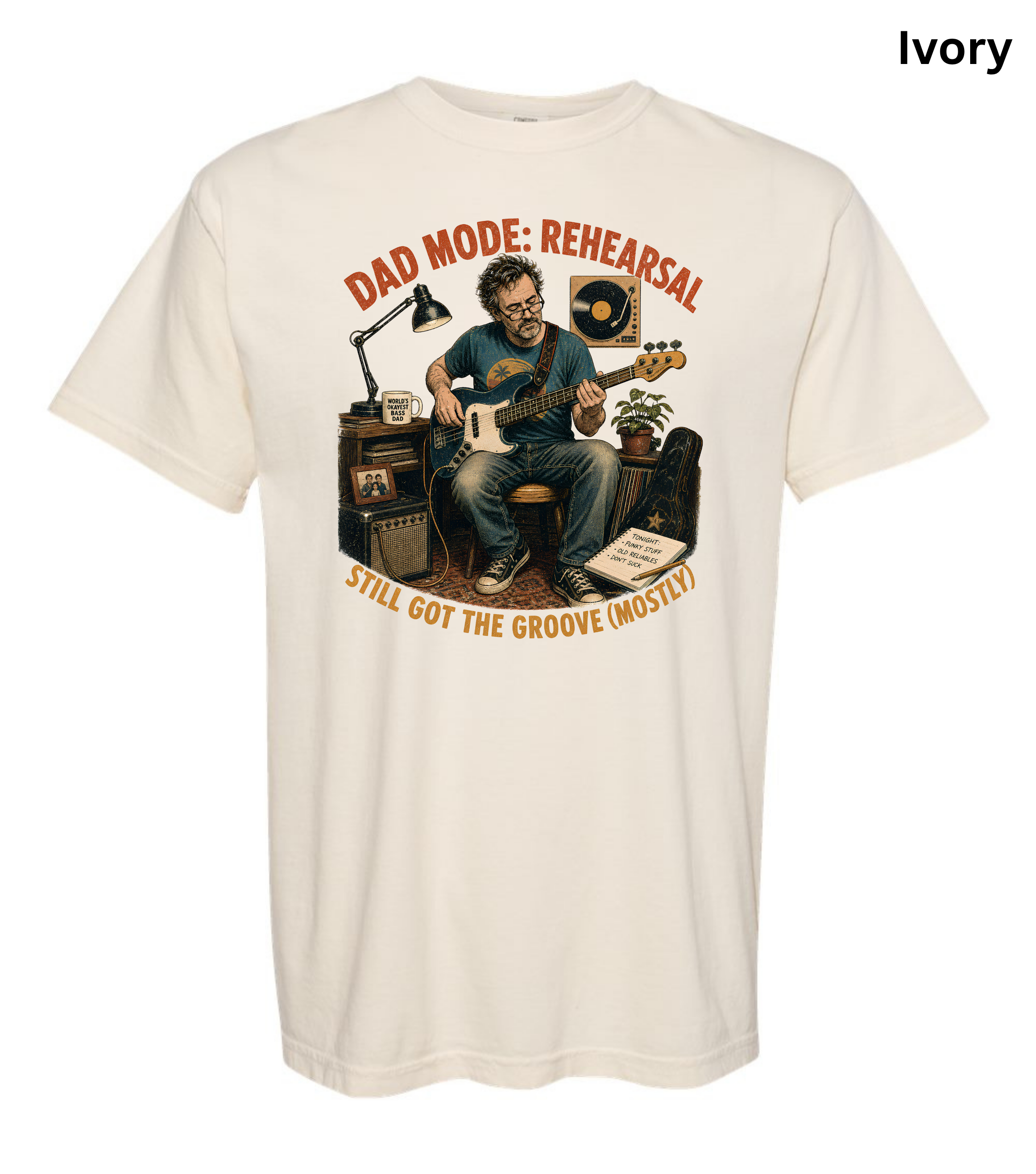 An ivory short-sleeve crewneck t-shirt featuring a graphic illustration of a man in a music studio with the text 'DAD MODE: REHEARSAL' and 'I STILL GOT THE GROOVE (MOSTLY!)'.