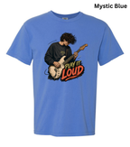 A light blue short-sleeve t-shirt with a graphic of a man playing an electric guitar and the text 'PLAY IT LOUD' in red, yellow, and black. The text 'Mystic Blue' is written in black in the top right corner.
