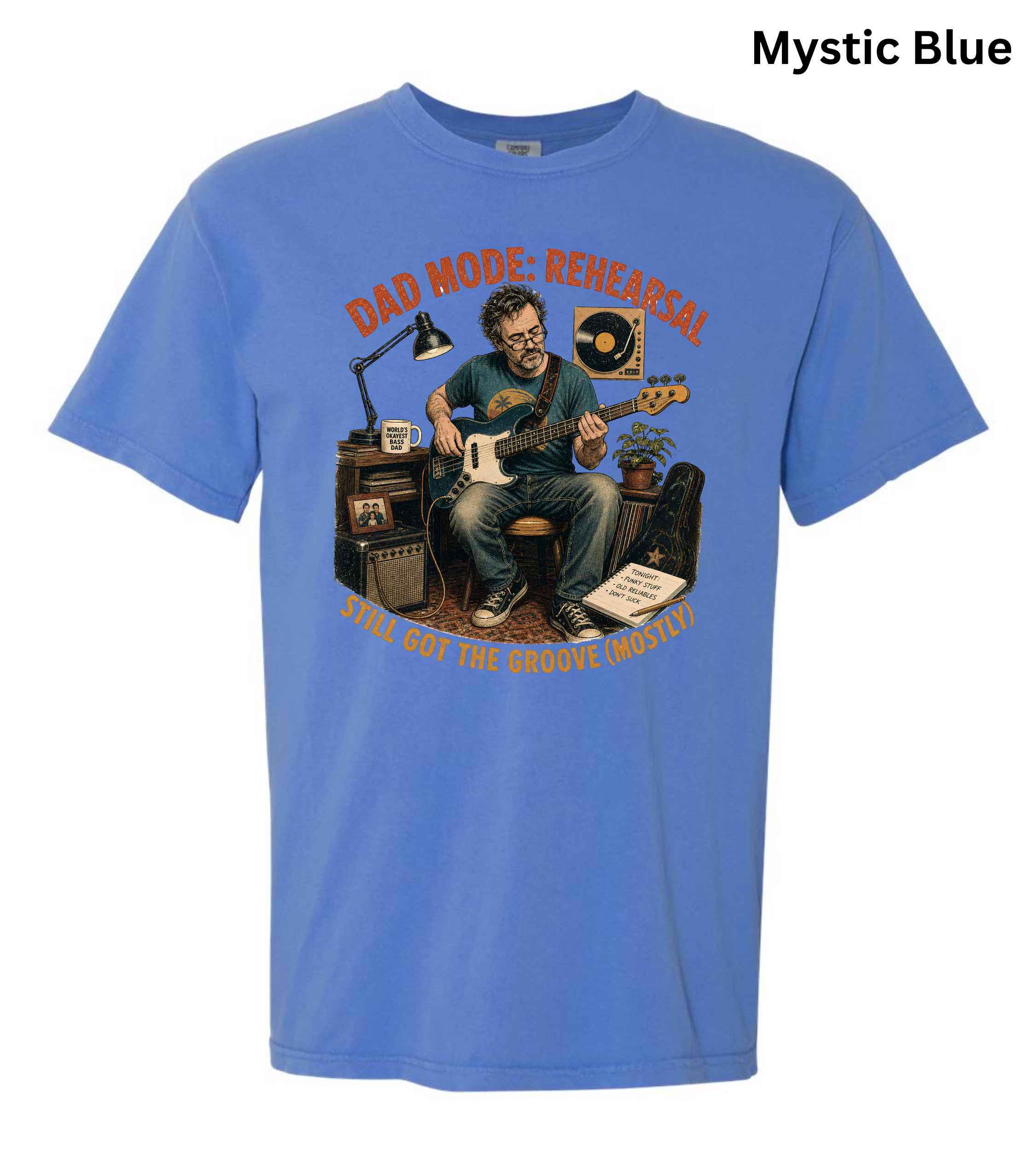 A blue short-sleeve crewneck t-shirt with a vintage-style graphic of a man playing an electric guitar in a studio setup, with the text 'DAD MODE-RESEARCH' and 'WHO WANTS THE MUSIC MEASTERS' in orange. The text 'Mystic Blue' is visible in the top right corner.