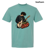 A seafoam green short-sleeve t-shirt with a graphic of a guitarist playing an electric guitar next to the text 'PLAY IT LOUD'. The brand name 'Seafoam' is printed in black in the top right corner.