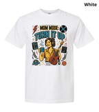 A white short-sleeve crewneck t-shirt featuring a colorful graphic print on the front with the text 'MOM MODE: TURN IT UP' and an illustration of a woman playing a red electric guitar with speakers and music notes.