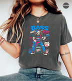 A woman wearing a dark gray graphic t-shirt with a colorful 'Bass Makes It Better' illustration, paired with blue jeans. The image is a close-up lifestyle shot showing the fit of the shirt.