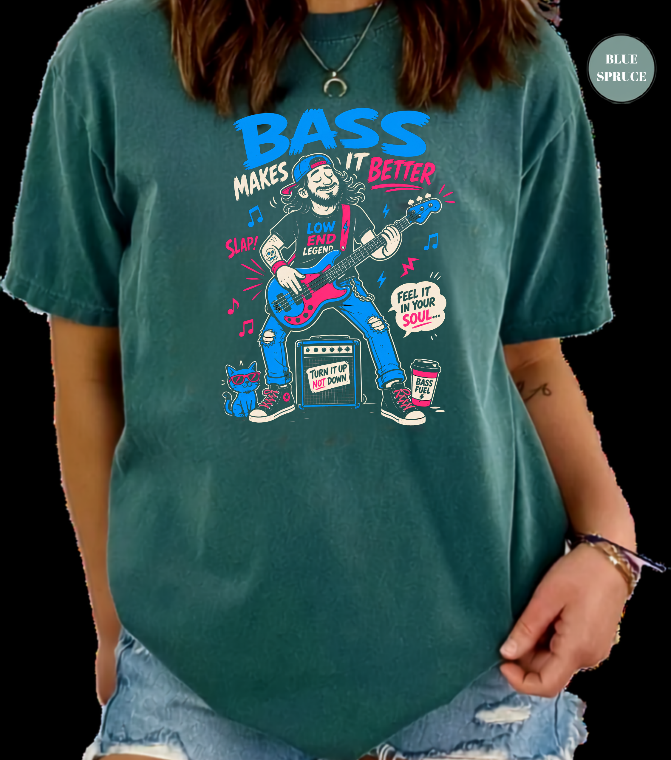 A person wearing a teal graphic t-shirt with a cartoon illustration of a man playing a guitar and the text 'BASS MAKES IT BETTER'. The background is solid black.