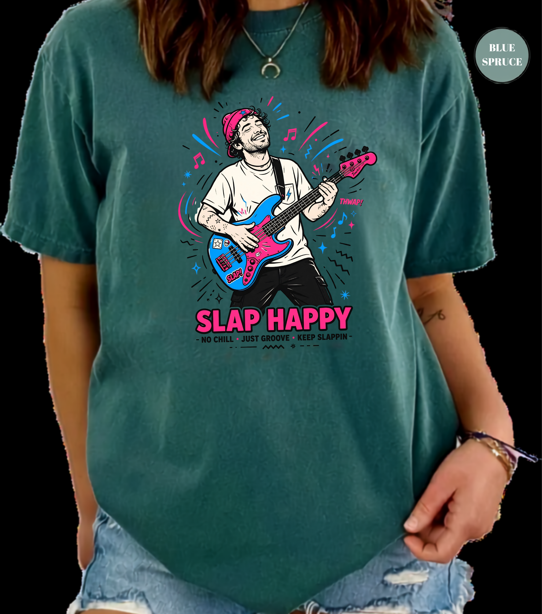 A person wearing a teal graphic t-shirt with a colorful illustration of a man playing a blue and pink bass guitar and the text 'SLAP HAPPY'. The background is solid black.