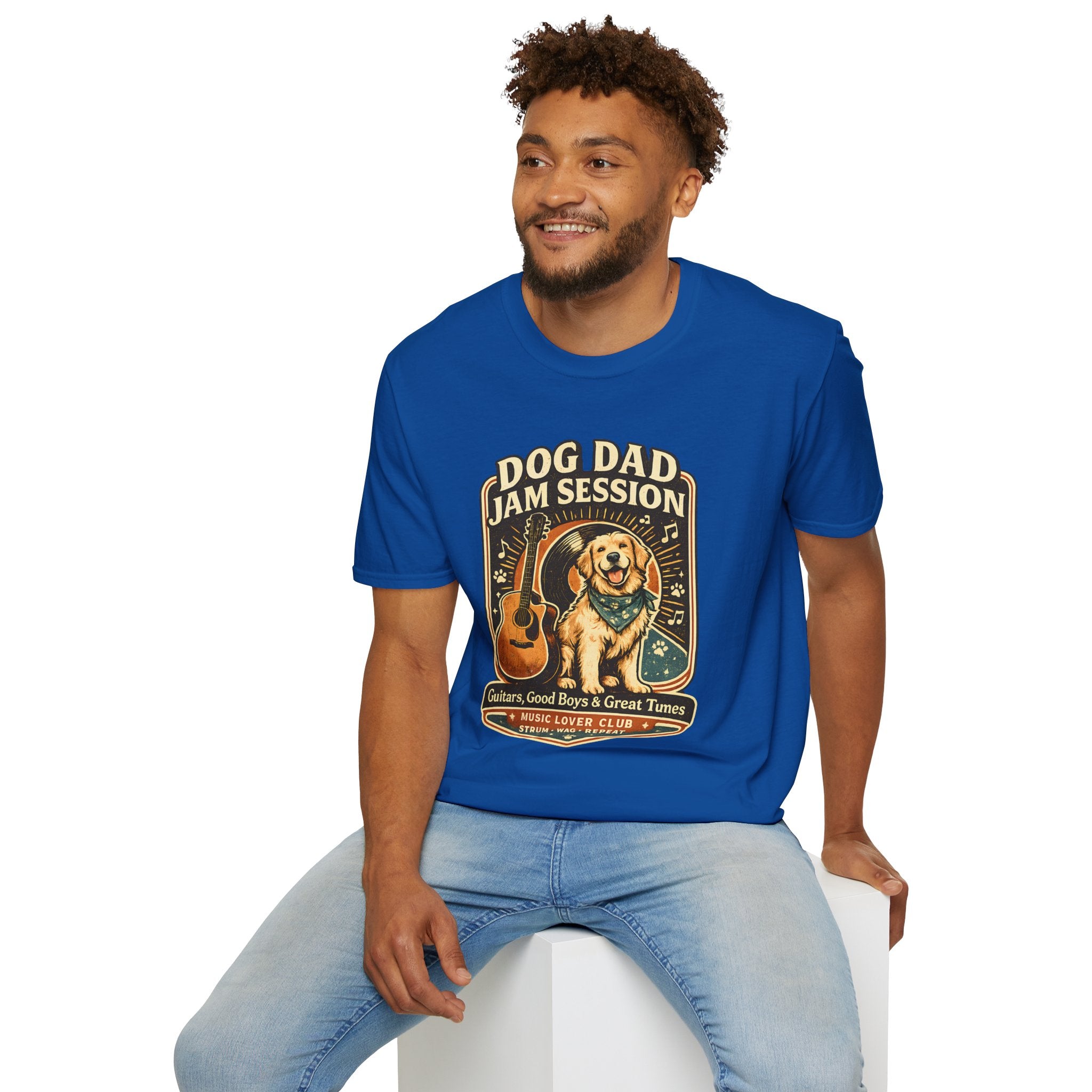Man wearing a blue t-shirt with a graphic design sitting on a white stool against a white background
