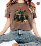 A person wearing a faded brown graphic t-shirt with a vintage-style illustration of a man playing an electric guitar in a recording studio. The text on the shirt reads 'BAD MODE.