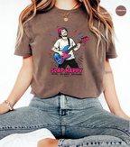 A woman wearing a brown graphic t-shirt with a colorful illustration of a guitarist and the text 'SLAP HAPPY'.