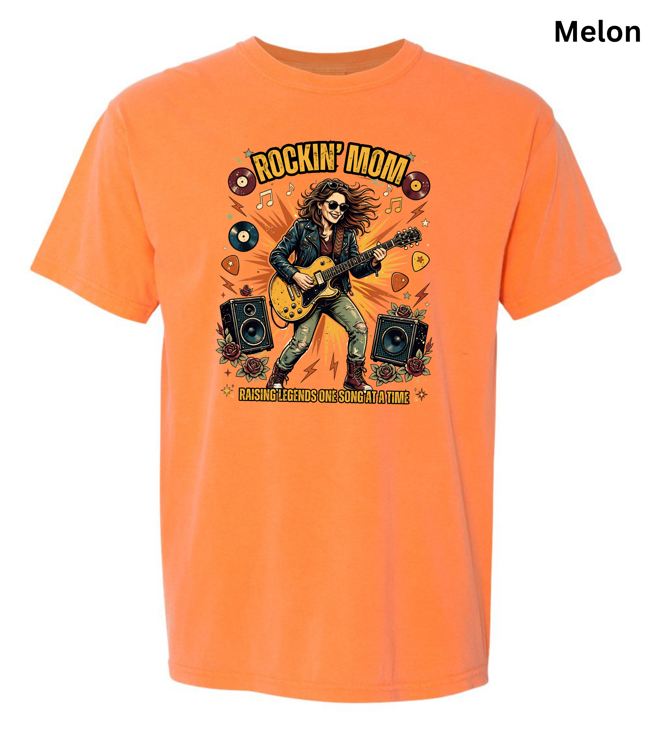An orange short-sleeve crewneck t-shirt featuring a colorful graphic of a rock musician playing an electric guitar with the text 'ROCKIN' MOM' and 'MAKE THE MUSIC YOURS TOMORROW'.