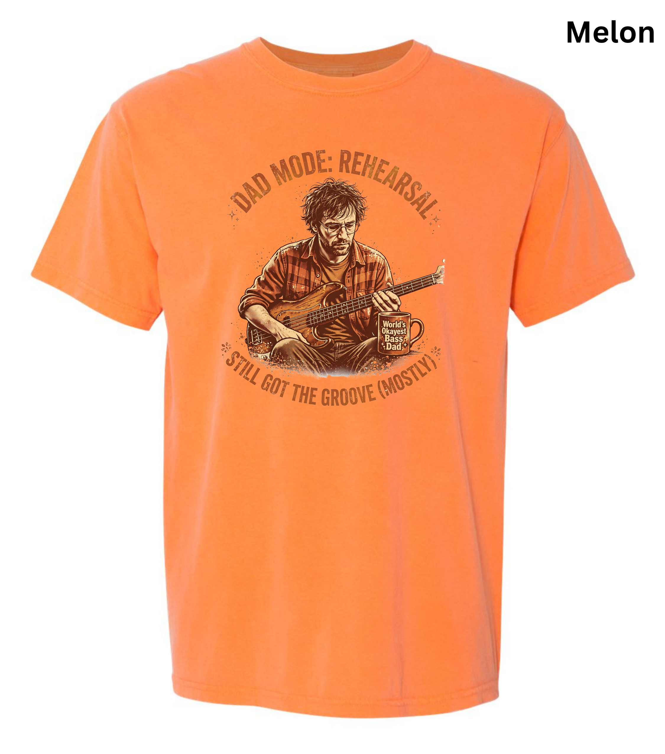An orange short-sleeve crewneck t-shirt featuring a vintage-style graphic of a man playing a guitar, with the text 'DAD MODE: REHEARSAL' and 'STILL GOT THE GROOVE (MOSTLY)'.