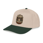 A structured baseball cap with a light beige crown and a dark forest green curved brim. The front of the cap features a detailed graphic print with the text 'ANTI SOCIAL NETWORK' and 'FRIENDSHIP IS LIFETIME'.